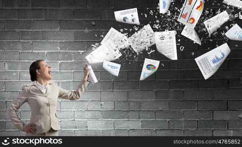 Woman with spray can. Young woman in suit with suitcase spraying paper sheets