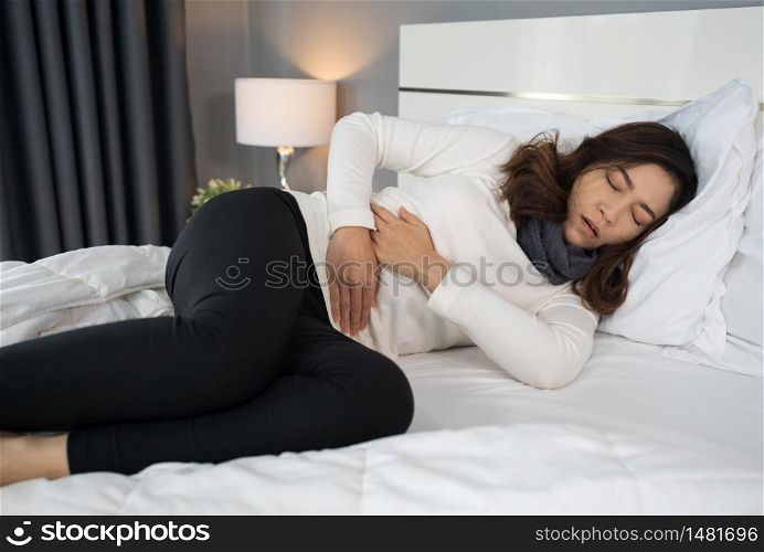 woman with stomach ache in a bed
