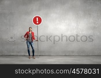 Woman with stop sign. Young lady in red jacket standing and holding stop sign