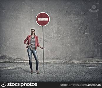 Woman with stop sign. Young lady in red jacket standing and holding stop sign
