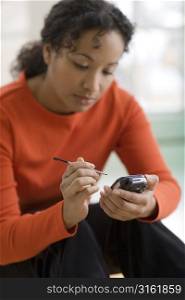 Woman with stylus looking at mobile phone
