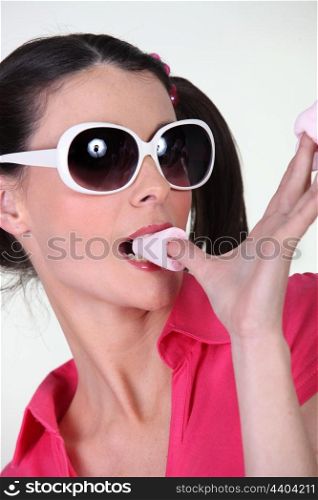 Woman with sunglasses eating sweets