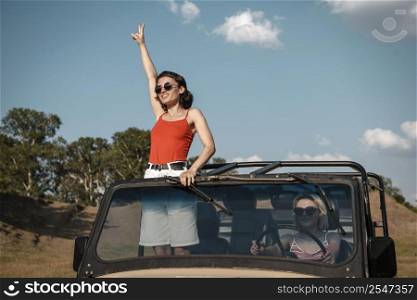 woman with sunglasses having fun while traveling by car