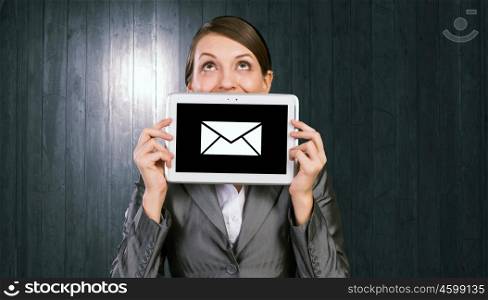 Woman with tablet. Beautiful young woman holding tablet against her mouth and smiling
