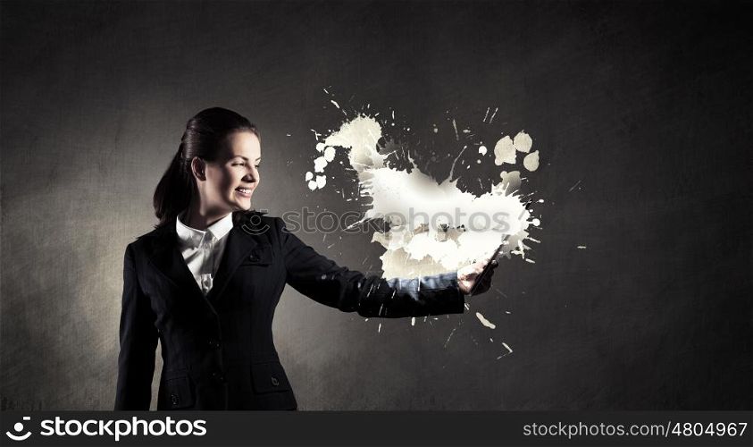Woman with tablet pc. Young businesswoman holding tablet on dark background
