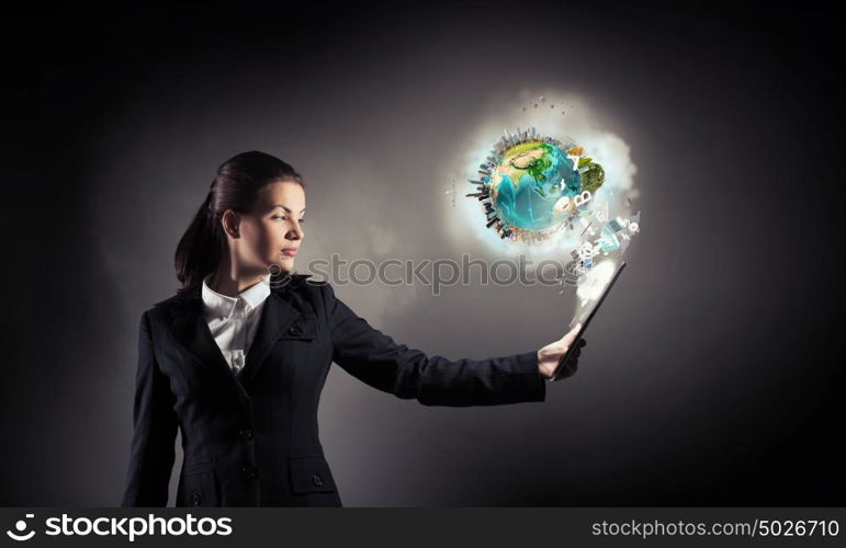 Woman with tablet pc. Young businesswoman holding tablet on dark background. Elements of this image are furnished by NASA