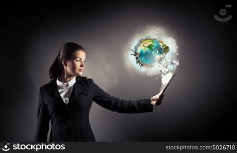 Woman with tablet pc. Young businesswoman holding tablet on dark background. Elements of this image are furnished by NASA