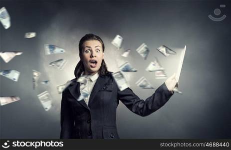 Woman with tablet pc. Young emotional businesswoman holding tablet on dark background