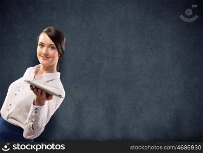 Woman with tablet pc. Young pretty businesswoman against grey background holding tablet pc