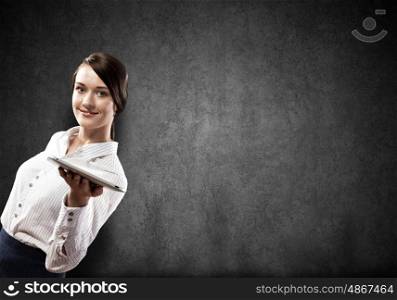 Woman with tablet pc. Young pretty businesswoman against grey background holding tablet pc