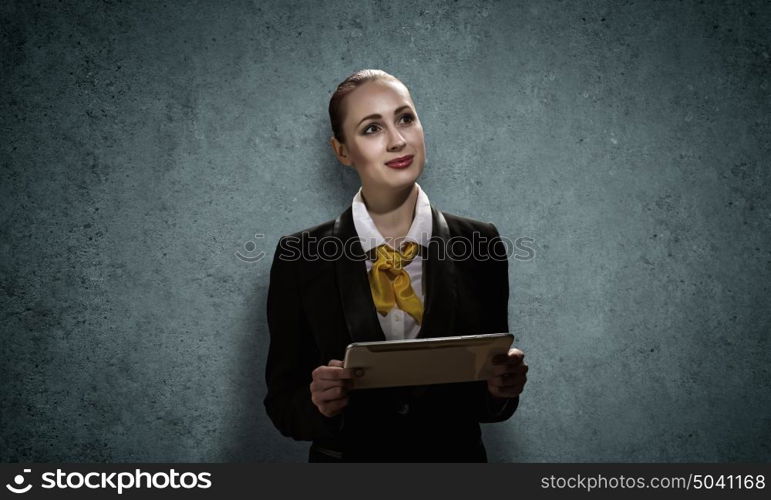 Woman with tablet pc. Young pretty businesswoman against grey background using tablet pc