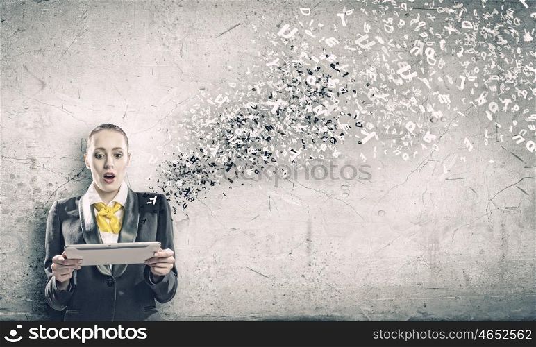 Woman with tablet pc. Young shocked woman holding tablet pc in hands and letters flying around
