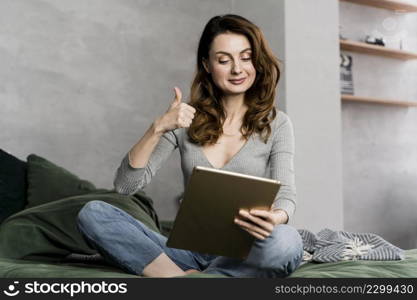 woman with tablet showing approval