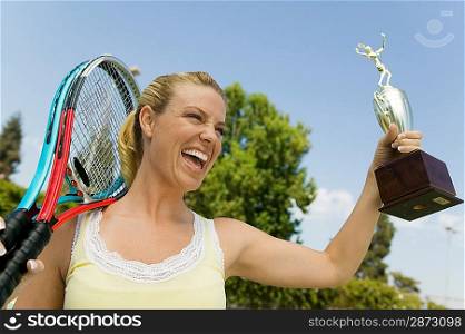 Woman with Tennis Rackets and Trophy