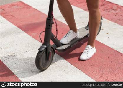 woman with tennis shoes riding scooter