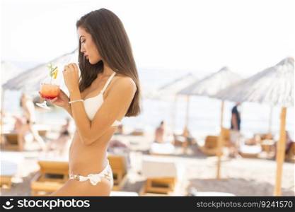 Woman with the drink on the beach