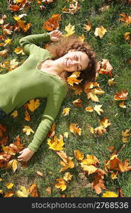 woman with the yellow leaf lies on the grass