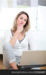 Woman with thoughtful look using laptop computer