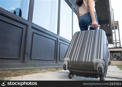 Woman with travel trolley luggage in hotel lobby.Travel concept.