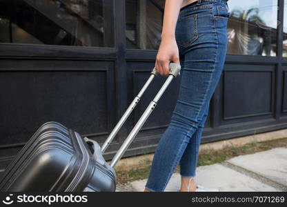 Woman with travel trolley luggage in hotel lobby.Travel concept.