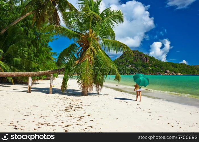 Woman with umbrella at beautiful beach at Seychelles