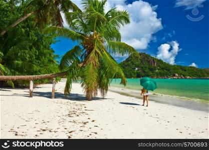 Woman with umbrella at beautiful beach at Seychelles