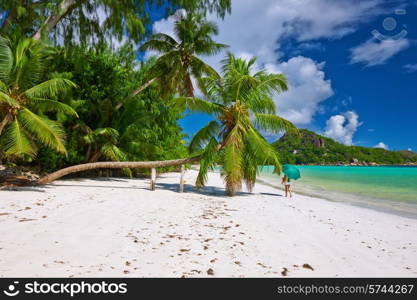 Woman with umbrella at beautiful beach at Seychelles