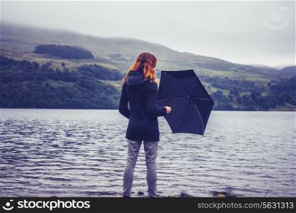 Woman with umbrella by a lake