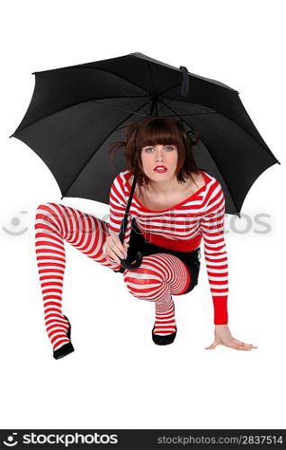 Woman with umbrella crouching