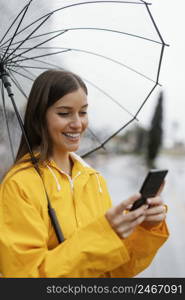 woman with umbrella using mobile phone