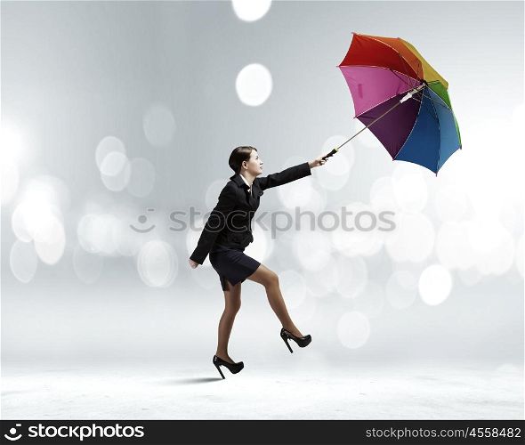 Woman with umbrella. Young businesswoman walking on roof with colorful umbrella