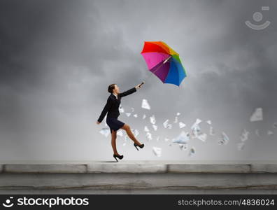 Woman with umbrella. Young businesswoman walking on roof with colorful umbrella