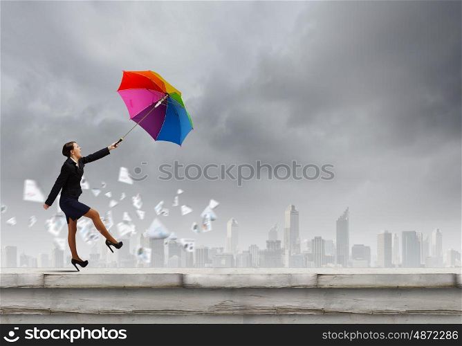 Woman with umbrella. Young businesswoman walking on roof with colorful umbrella