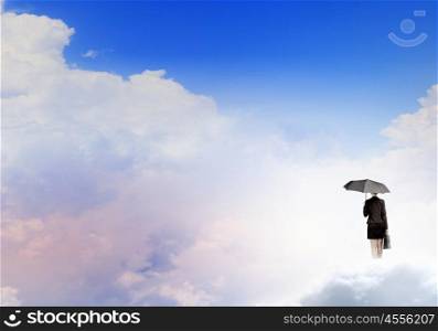 Woman with umbrella. Young businesswoman with black umbrella standing on cloud