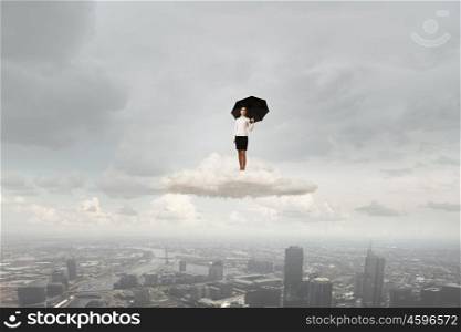 Woman with umbrella. Young businesswoman with black umbrella standing on cloud
