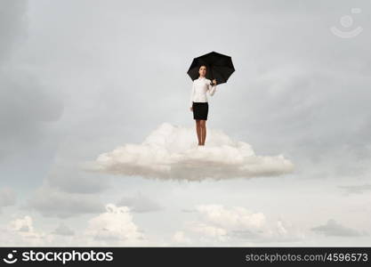 Woman with umbrella. Young businesswoman with black umbrella standing on cloud