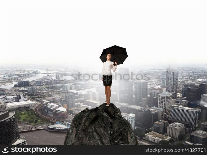 Woman with umbrella. Young businesswoman with black umbrella standing on top