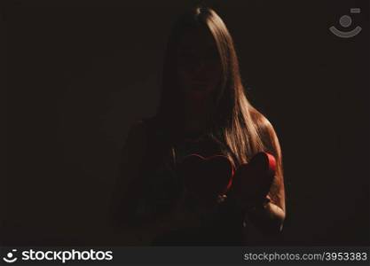 Woman with valentines box. Valentine day. Woman in black holding heart box gift present. Elegant attractive model with valentines symbol sign. Studio shot.