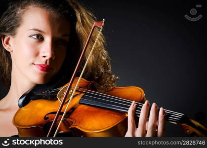 Woman with violin in dark room