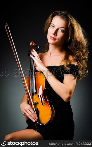 Woman with violin in dark room