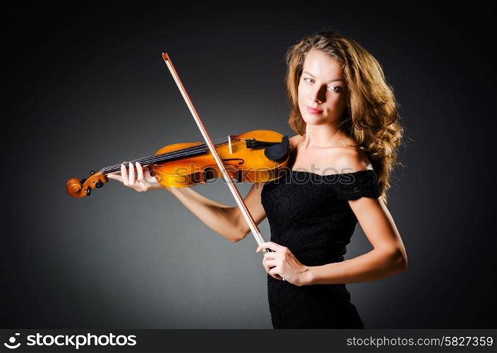 Woman with violin in dark room