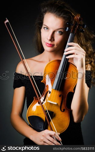 Woman with violin in dark room