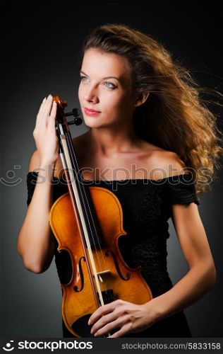 Woman with violin in dark room