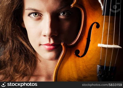 Woman with violin in dark room