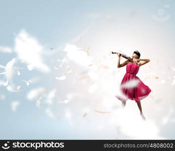 Woman with violin. Pretty lady in red dress playing violin