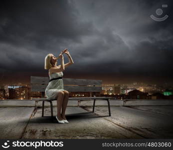 Woman with violin. Young woman sitting on bench and playing fife