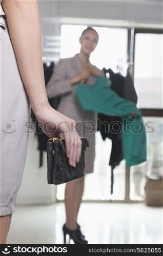 Woman with wallet at fashion store, close-up