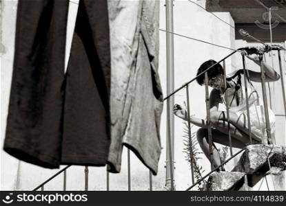 Woman with washing and courtyard steps, Lisbon, Portugal