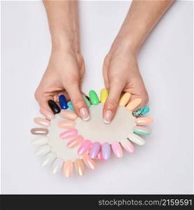 woman with well-groomed hands and healthy nails holding palette with swatches collection of nail Polish for manicure.. woman with well-groomed hands and healthy nails holding palette with swatches collection of nail Polish for manicure