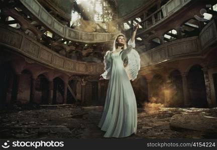 Woman with wings in a decaying building.